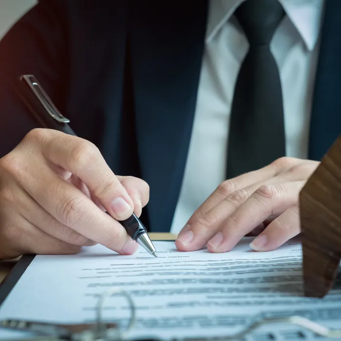 Persona en traje firmando documento